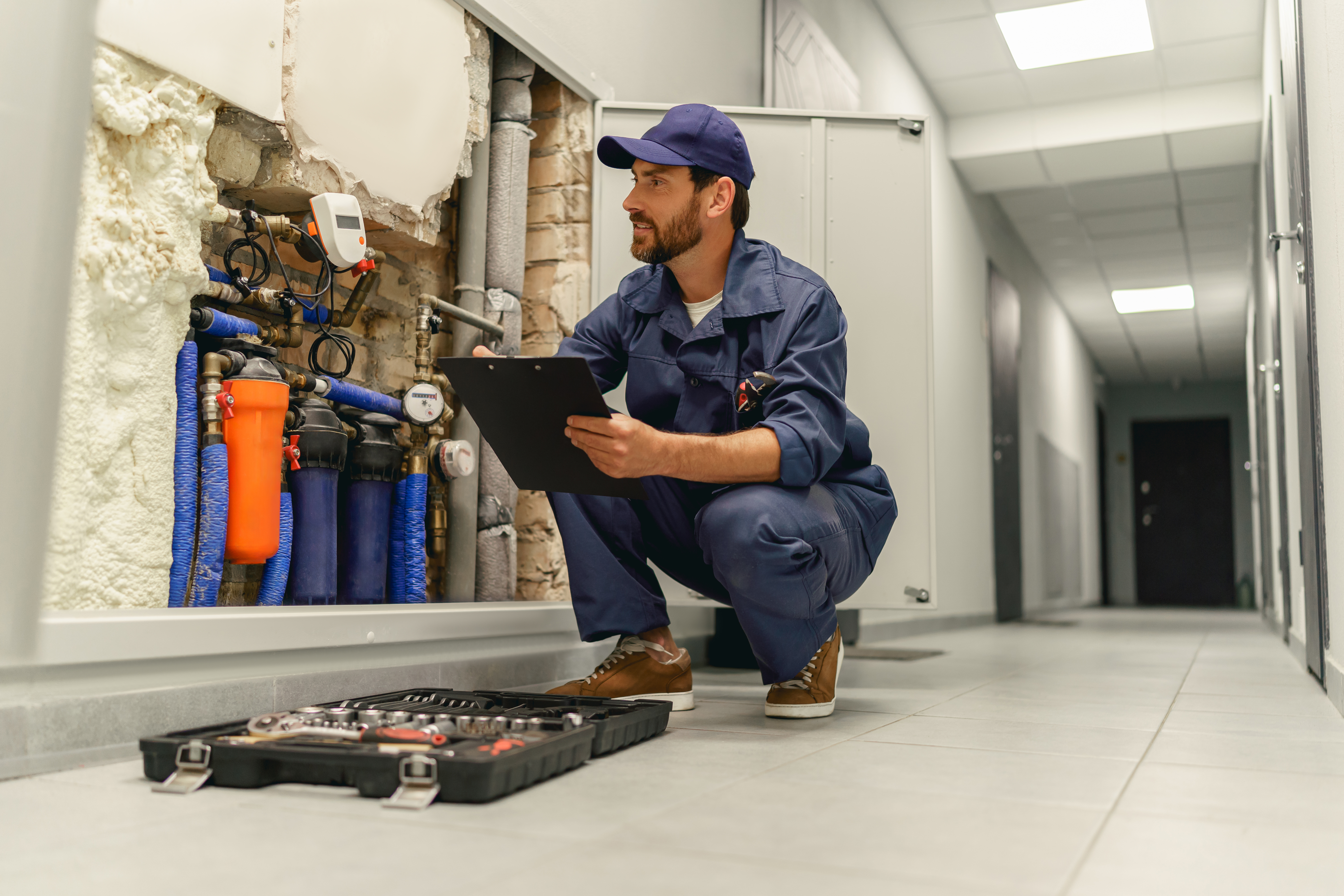 Technicien vérifiant un système de chauffage en intérieur.